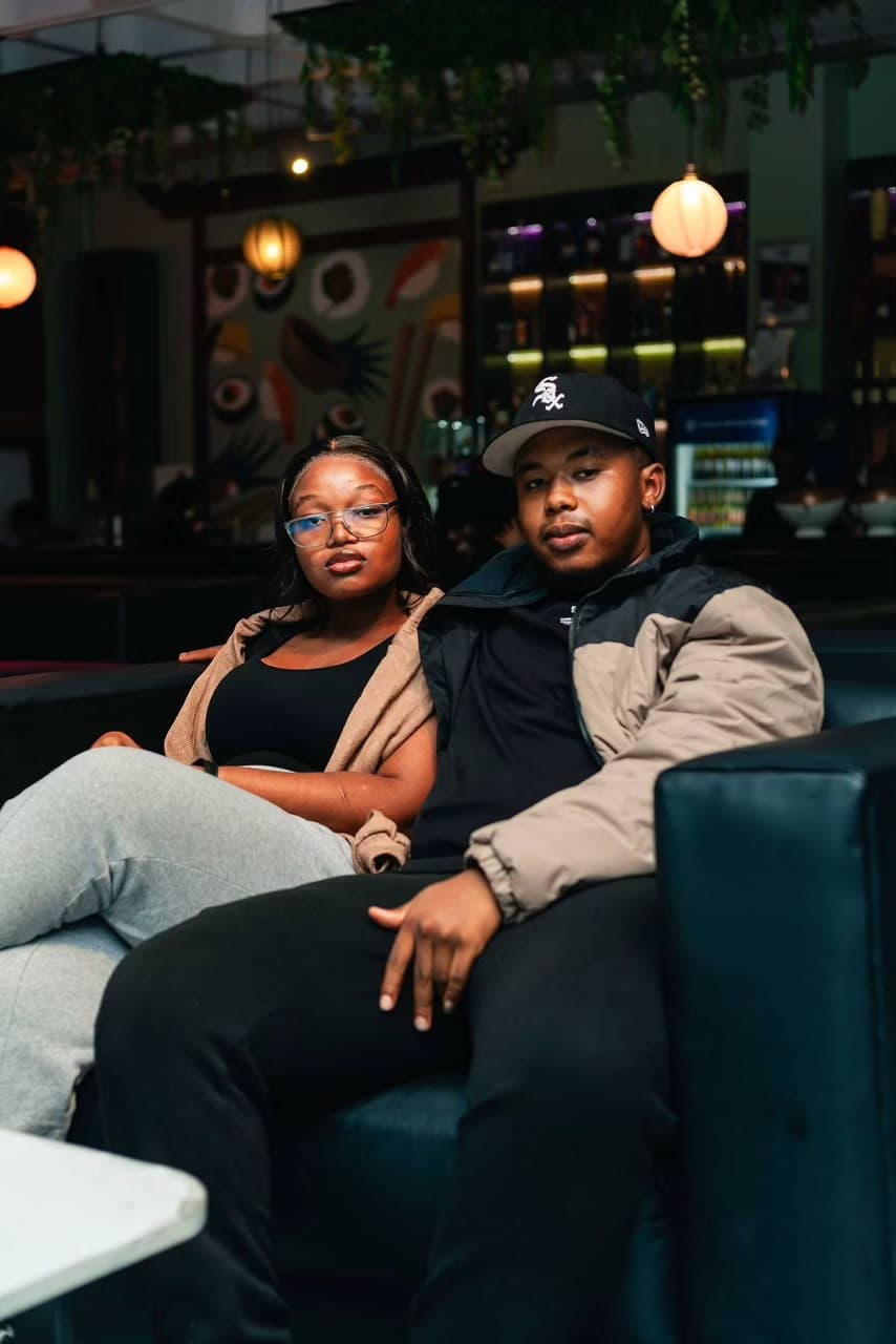 A couple relax together in a plush VIP lounge booth.