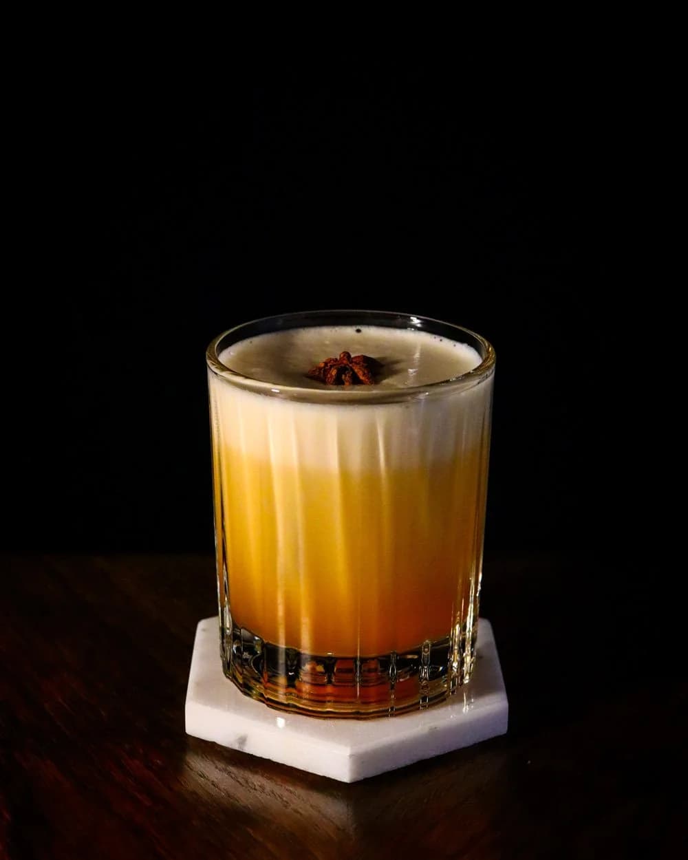 The ZEN Sour — a layered amber whiskey cocktail with a foam top, finished with cherry bitters.