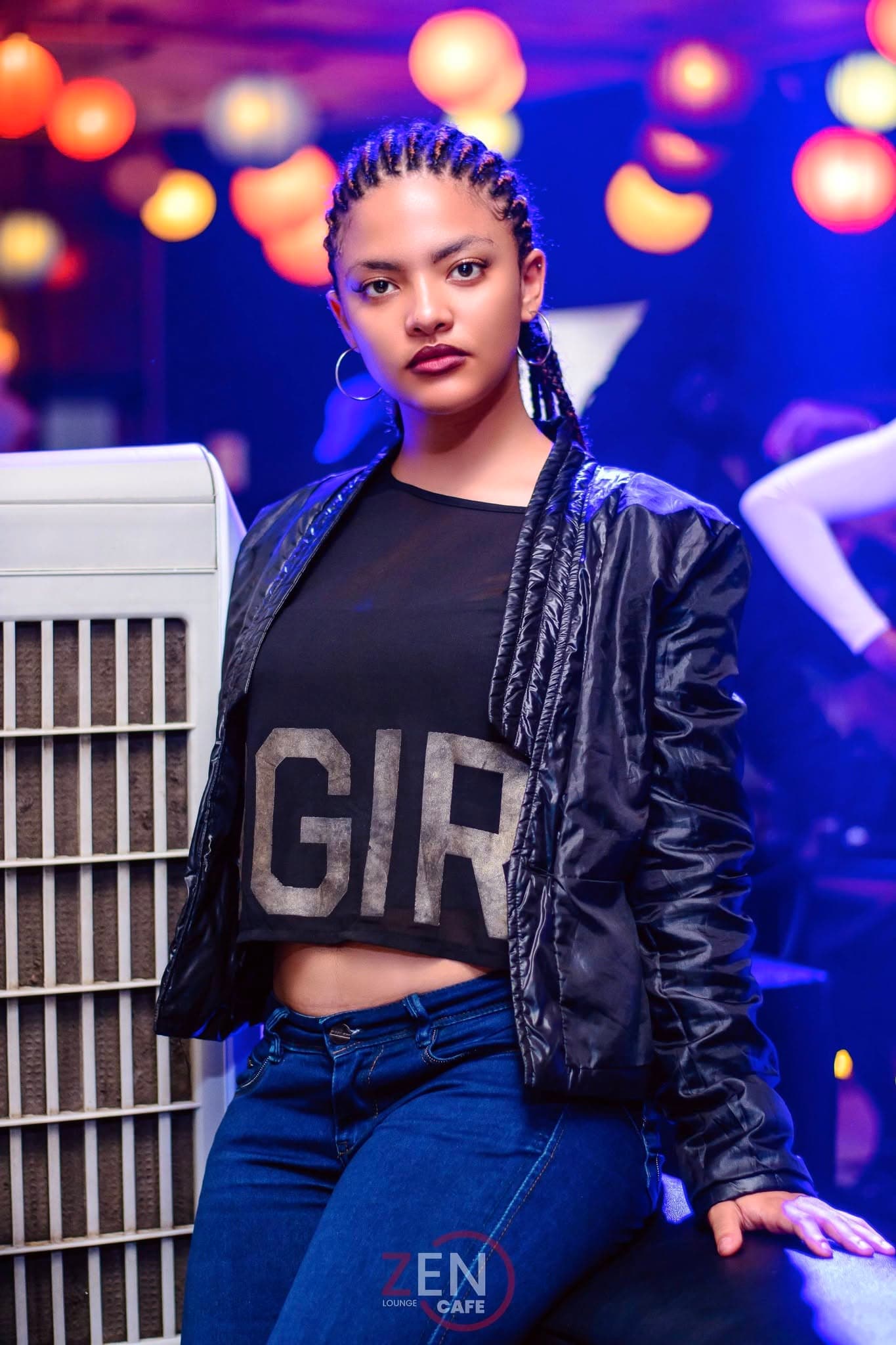A guest poses in a cropped 'GIRL' tee and black jacket beneath a canopy of warm paper lanterns at Zen Cafe Lounge.