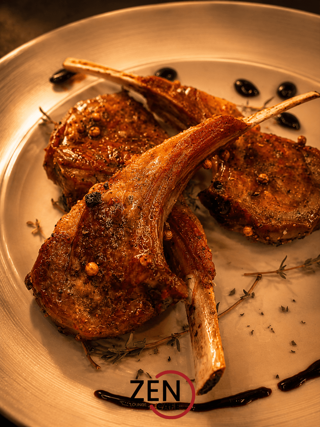 Grilled lamb chops seasoned with cracked pepper and thyme, plated with a balsamic reduction.